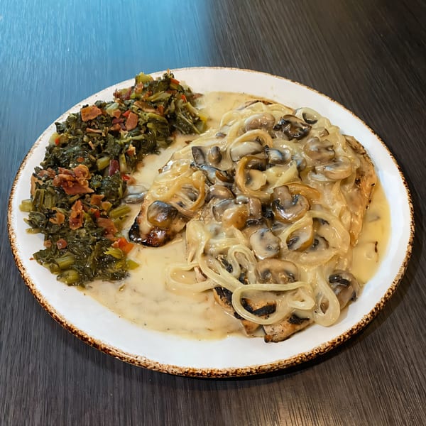 Chicken smothered in mushroom and onion gravy, served with collard greens and bacon bits.